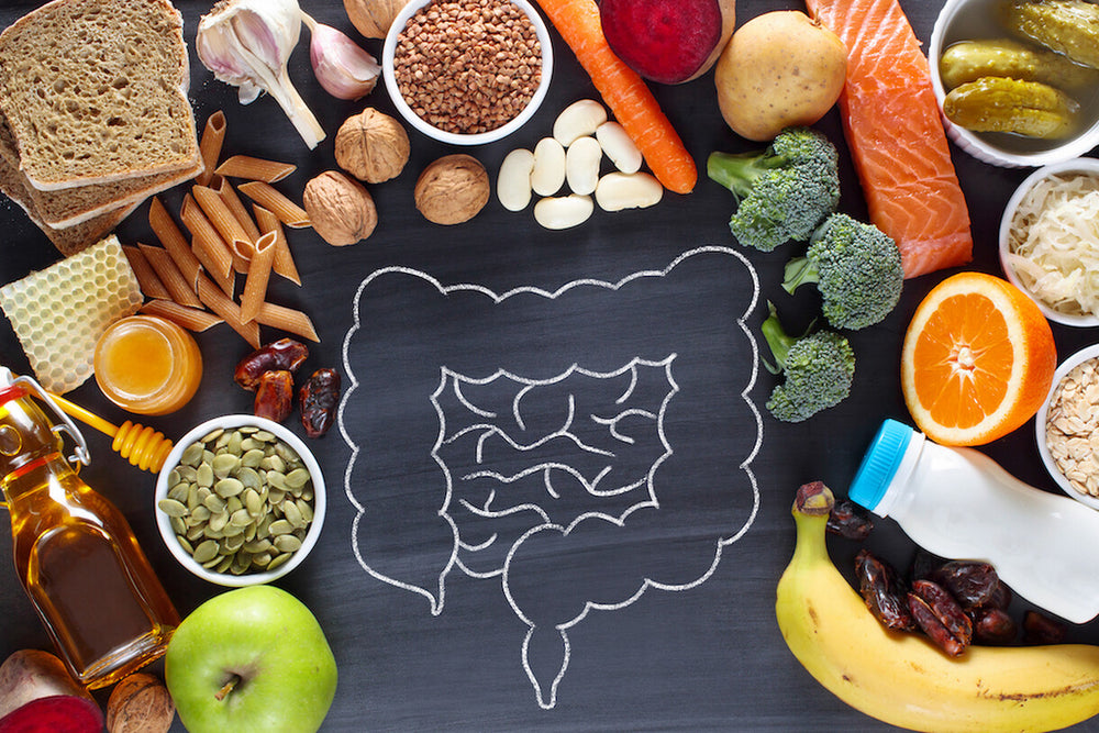 Food layed out on table with a chalk drawing of intestines and digestive track